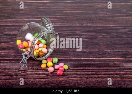 Bonbons multicolores dans un pot en verre Banque D'Images