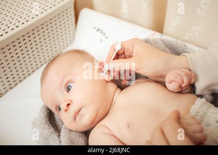 Maman nettoie les oreilles de l'enfant, l'amour et les soins, les soins du corps. Banque D'Images