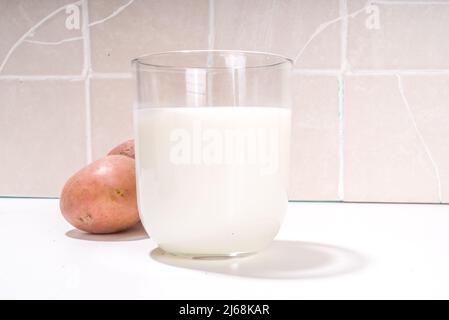 Lait de pomme de terre végétalien de remplacement, boisson crémeuse non laitière, avec pomme de terre sèche, crue et bouillie Banque D'Images