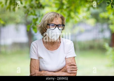 Femme âgée portant un masque de protection contre le virus corona Banque D'Images