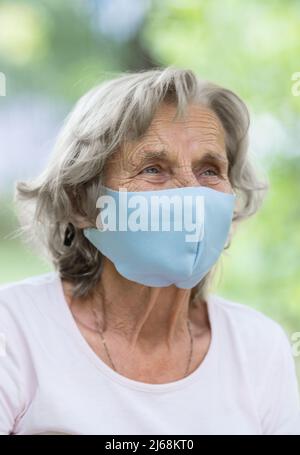 Femme âgée portant un masque de protection contre le virus corona Banque D'Images