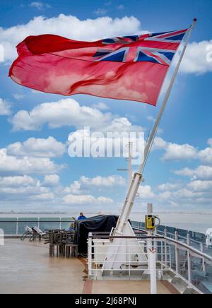 Le drapeau de l'Ensign rouge volant sur un mât attaché à la poupe du navire Cunard, RMS Queen Elizabeth Banque D'Images