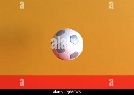 Ballon de football sur fond orange et rouge 3D rendu Banque D'Images