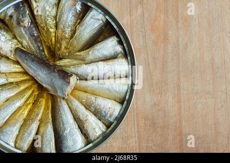 Un gros plan d'une sardine en conserve sur fond de bois rustiques et abîmé avec espace de copie. Poisson et nutrition. Banque D'Images