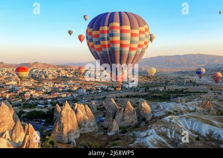 GÖREME, TURQUIE - 4 OCTOBRE 2020 : de nombreux ballons flottent dans l'air au-dessus de la Cappadoce dans les premiers rayons du soleil levant. Banque D'Images