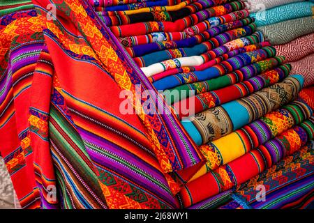 Châles/couvertures colorées à vendre dans le marché de Pisac, la Vallée Sacrée, province de Calca, Pérou. Banque D'Images