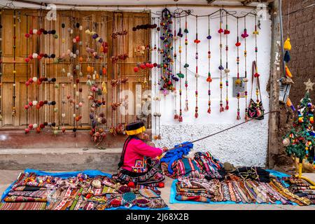 Une femme indigène en costume traditionnel Affichage de la méthode traditionnelle de la laine de tissage dans la ville de Pisac, la Vallée Sacrée, province de Calca, Banque D'Images