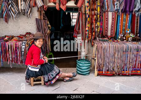 Femme autochtone montrant la méthode traditionnelle de la laine de tissage dans la ville de Pisac, la Vallée Sacrée, province de Calca, Pérou. Banque D'Images