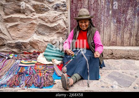 Femme autochtone montrant la méthode traditionnelle de la laine de tissage dans la ville de Pisac, la Vallée Sacrée, province de Calca, Pérou. Banque D'Images