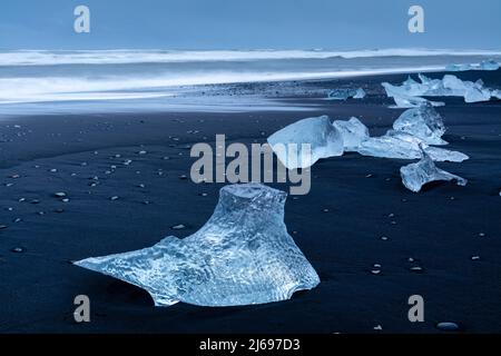 Icebergs du glacier en fusion sur une plage de sable noir près de la lagune du glacier de Jokulsarlon, parc national de Vatnajokull, Islande Banque D'Images