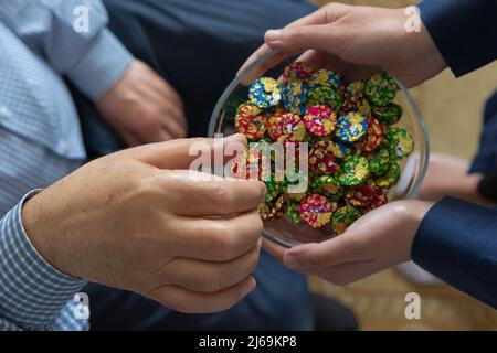 Homme aîné prenant un sucre ou un chocolat d'un bol dans Eid al-adha ou eid al-fitr. Festival de culture religieuse turque. Iyi bayramlar. Mise au point sélective Banque D'Images