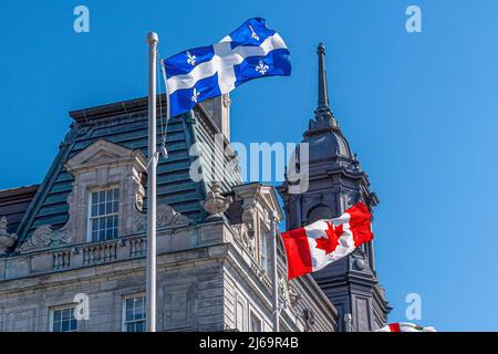 Drapeaux du Québec et du Canada agitant dans l'hôtel de ville ou l'hôtel de ville de la vieille ville. Le quartier historique est un site classé au patrimoine mondial de l'UNESCO et un Banque D'Images