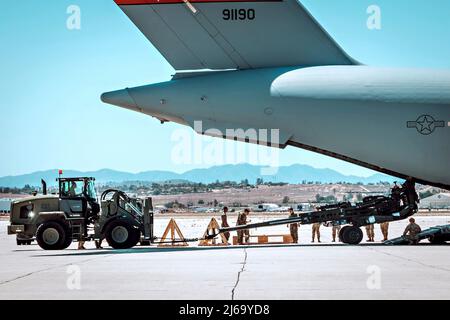 Riverside, États-Unis. 24 avril 2022. Les Marines des États-Unis chargent un obusier de 155 mm remorqué de M777 à l'arrière d'un avion C-17 Globemaster III de la U.S. Air Force à la base de réserve aérienne de mars, le 24 avril 2022 près de Riverside, en Californie. Les obusiers sont expédiés en Ukraine pour aider à repousser l'invasion russe. Crédit : SSTGT. Royce H. Dorman/US Marines photo/Alamy Live News Banque D'Images