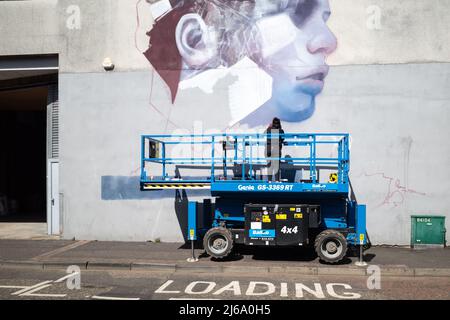 Artiste de rue peignant une fresque dans la ville de Larne, en Irlande du Nord Banque D'Images