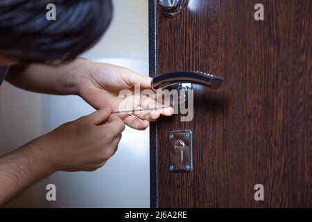 Serrurier remplaçant la serrure de porte par une serrure neuve après avoir perdu les clés. Protection contre les vols, amélioration de la sécurité. Un réparateur ou un ouvrier change ou répare le verrou de la porte. Banque D'Images