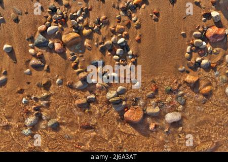 Directement au-dessus de Flatlay de vagues douces Lapping Sand et Pebble Beach avec l'eau claire et fraîche immaculée Banque D'Images