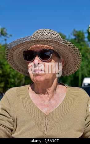 Femme âgée souriant sur les bains de soleil Banque D'Images