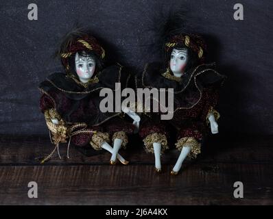 Jouets vintage réalistes en porcelaine avec yeux gris. Les poupées sont vêtues d'une tenue de carnaval, décorées avec de l'or. Style italien ancien. Banque D'Images