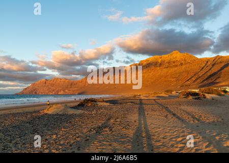 Plage de Famara et montagnes de Risco de Famara au coucher du soleil, Espagne Banque D'Images