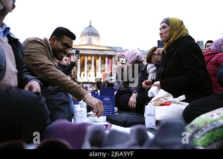 Les gens pendant un Iftar ouvert pour marquer la dernière semaine du Ramadan, organisé par le projet de tente du Ramadan, pour rassembler des gens de toutes les communautés pour partager un Iftar (repas du soir) pour se briser rapidement pendant le mois Saint islamique du Ramadan, à Trafalgar Square, dans le centre de Londres. Date de la photo: Vendredi 29 avril 2022. Banque D'Images