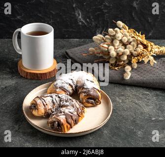 Tasse de thé noir, pâtisseries traditionnelles au chocolat, saule sur fond sombre, photo Banque D'Images