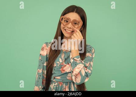 Heureux Tween fille sourire portant des lunettes de soutien en forme de coeur pour la fête de jour de Valentines, février 14 Banque D'Images