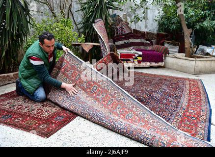 (220429) -- ALEP (SYRIE), 29 avril 2022 (Xinhua) -- Omar Rawas, un tisserand de tapis, vérifie un tapis à son atelier d'Alep (Syrie), le 8 mars 2022. Avant l’éruption de la guerre en Syrie en 2011, la réparation des tapis était principalement destinée à réparer les tapis artisanaux anciens et coûteux, considérés comme du patrimoine et des trésors en raison de leur valeur. Cependant, la situation a changé maintenant que les gens ne peuvent guère se permettre de nouveaux tapis coûteux dans un contexte de crise économique résultant des longues années de guerre et des sanctions économiques sévères imposées par les États-Unis à la Syrie. (Photo par Ammar Safarja Banque D'Images