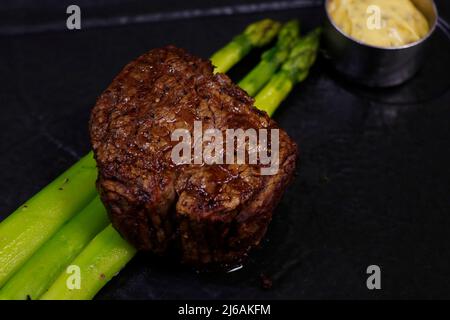 filet de bœuf angus grillé avec asperges et sauce hollandaise dans une assiette Banque D'Images