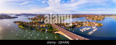 Panorama aérien sur le pont de Gladesville à travers la rivière Parramatta à l'ouest de Sydney, face à l'horizon lointain du centre-ville. Banque D'Images