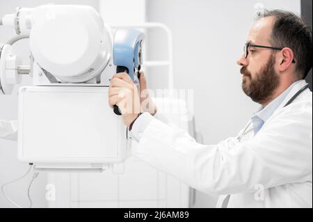 Médecin exploitant un appareil à rayons X dans le service de radiologie. Photographie de haute qualité Banque D'Images