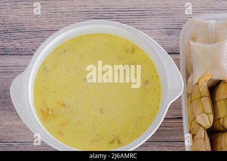 « Ketupas & Lodeh » . Plat traditionnel de célébration de gâteau de riz avec plusieurs plats d'accompagnement, populairement servi pendant les célébrations d'Eid Banque D'Images