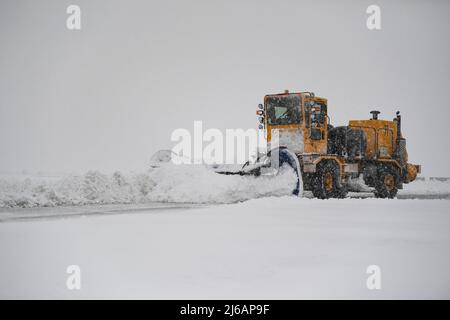 Un membre de l'escadron du génie civil 319th utilise un chasse-neige pour nettoyer la ligne de vol pendant un blizzard à la base aérienne de Grand Forks, N.D., le 12 avril 2022. Par mauvais temps, l'équipe travaille de jour comme de nuit pour éliminer la neige et rétablir la fonctionnalité du terrain d'aviation. (É.-U. Photo de la Force aérienne par l'homme principal, Dakota C. Legrand) Banque D'Images