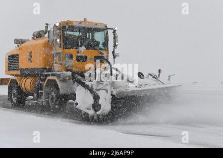 Un membre de l'escadron du génie civil 319th exploite un balai de neige pour nettoyer la ligne de vol pendant un blizzard à la base aérienne de Grand Forks, N.D., le 12 avril 2022. La base a reçu près d'un pied de neige en moins de 24 heures. (É.-U. Photo de la Force aérienne par l'homme principal, Dakota C. Legrand) Banque D'Images