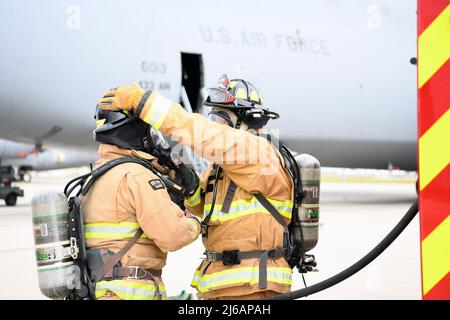 Les pompiers de l'escadron du génie civil du 902nd se préparent à entrer dans une Super Galaxy de l'escadre du 433rd Airlift C-5M lors d'un exercice visant à simuler un incendie au frein le 18 novembre 2021, à la base interarmées de San Antonio-Lackland, au Texas. L'exercice de force totale a permis aux pompiers de suivre une formation pratique sur la procédure de sortie des avions et des équipages. (É.-U. Photo de la Force aérienne par le Sgt. Kristian carter) Banque D'Images