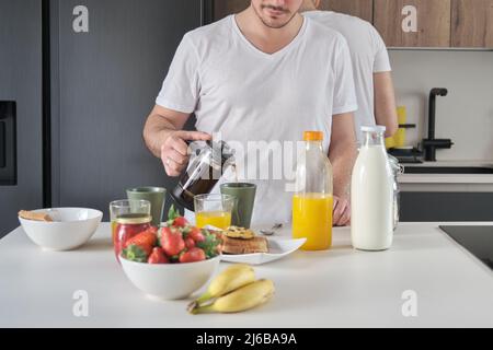 Homme méconnu qui verse du café dans une tasse. Banque D'Images
