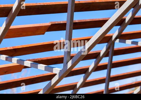 Cadre de toit en acier avec des panneaux en bois, structure de construction moderne est sous le ciel bleu profond lors d'une journée ensoleillée d'été Banque D'Images