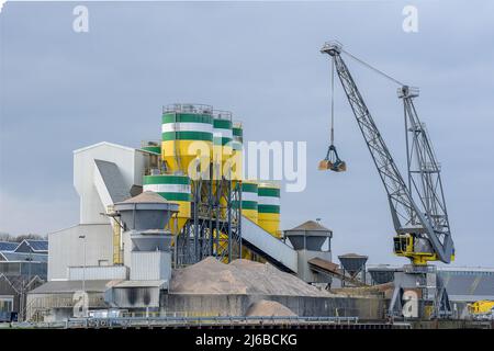 Usine de ciment avec grues pour le transport de matières premières. Les silos dans lesquels les matières premières sont mélangées dans le ciment et les tapis transporteurs sont clairs Banque D'Images