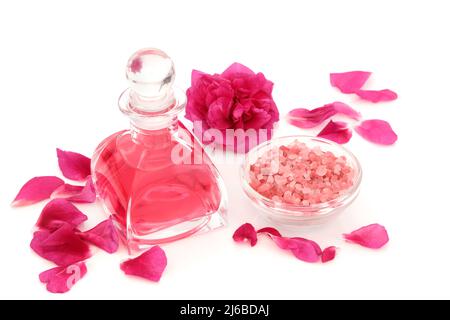 Eau de rose dans une bouteille en verre art déco avec fleur, pétales et sel himalayan pour un soin beauté exfoliant. Concept de soin naturel de la peau pour restaurer la peau. Banque D'Images