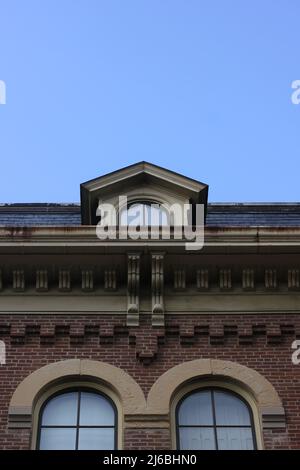 Une fenêtre traditionnelle de grenier colonial haut sur la ligne de toit. Banque D'Images