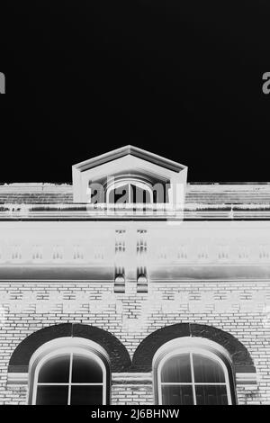 Une fenêtre traditionnelle de grenier colonial haut sur la ligne de toit en négatif de film de contraste élevé. Banque D'Images