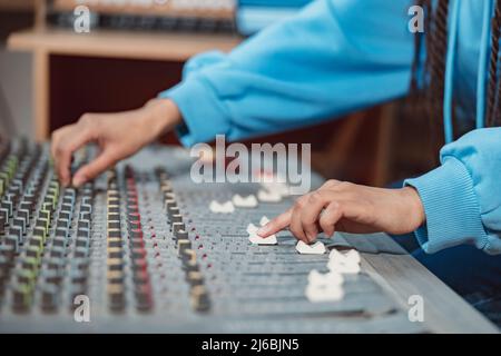 Femme ingénieur du son, musicien producteur mains utilisant le tableau de mixage et le logiciel pour créer la chanson dans le studio d'enregistrement Banque D'Images