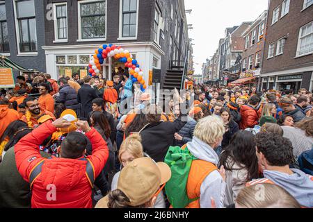 Des foules de personnes vues dans les rues d'Amsterdam lors de la fête du Roi. La Journée du roi, connue sous le nom de Koningsdag, est une célébration orange pour l'anniversaire du roi, une fête nationale pleine d'événements à travers le pays. Des milliers de fêtards et de touristes locaux ont visité Amsterdam pour célébrer et faire la fête autour des canaux tout en portant des vêtements orange et les bateaux faisant une parade dans les canaux d'eau. Banque D'Images