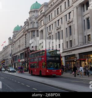 Londres, Grand Londres, Angleterre, avril 23 2022 : circulation sur Regent Street sous Green Domed architecture y compris un bus, pousse-pousse près d'un arrêt de bus comme Banque D'Images