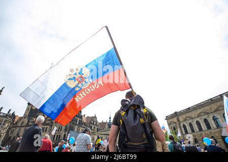 30 avril 2022, Saxe, Dresde: Un homme a un drapeau russe sur son épaule. Environ 100 personnes sont venues au rassemblement pro-russe sur Theaterplatz à Dresde intitulé "paix mondiale, pas de guerre en Europe, compréhension internationale, pas de propagande politique dans les écoles". Photo: Daniel Schäfer/dpa Banque D'Images