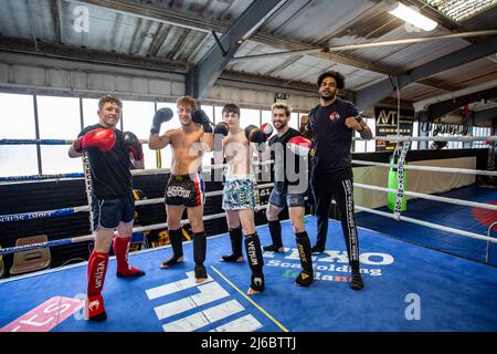 Un groupe de jeunes étudiants thaïlandais en boxe posant sur une plate-forme de boxe dans un gymnase local du West Yorkshire, en Angleterre. Banque D'Images