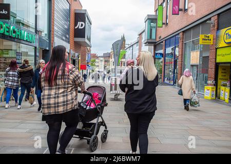 Mère avec des promenades de bébé dans le centre commercial Trinity Walk à Wakefield, West Yorkshire, Angleterre. Banque D'Images