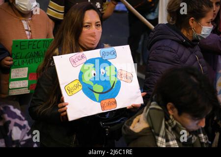 Buenos Aires, Argentine; 22 avril 2022: Manifestation du jour de la Terre; femme tenant un signe avec une photo de la planète souriante entourée des mots: r Banque D'Images