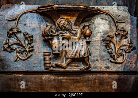 Misericords sont de petites structures en bois formées sur le dessous d'un siège pliant dans une église.ici vu dans l'église paroissiale de Saint-Laurent à Ludlow. Banque D'Images