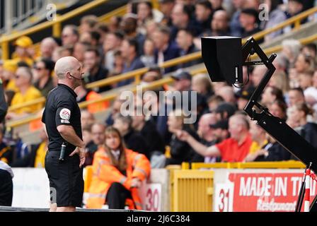 L'arbitre Simon Hooper vérifie la présence d'un handball au VAR lors du match de la Premier League au stade Molineux, Wolverhampton. Date de la photo: Samedi 30 avril 2022. Banque D'Images