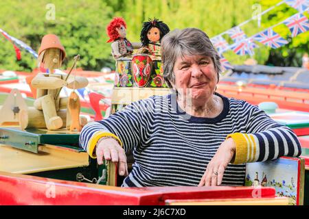 Londres, Royaume-Uni, 30th avril 2022. Une dame se détend et regarde les gens marcher sur le M&JA Moorse. Des dizaines de barques étroites, barges et canots admirablement décorés participent au festival IWA Canalway Cavalcade qui revient à la petite Venise de Londres pour le week-end des fêtes de fin d'année de la Banque du début du mois de mai. Organisée par l'Inland Waterways Association (IWA), elle célèbre la vie des bateaux avec un spectacle de bateau, ainsi que de la musique, des stands et des divertissements en famille le long du canal de Grand Union. Banque D'Images